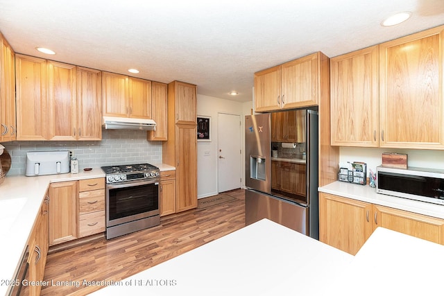 3855 Sandlewood Dr, Okemos, MI 48864 - kitchen with stainless steel gas range, built in fridge, under cabinet range hood, white microwave, and light wood-style flooring