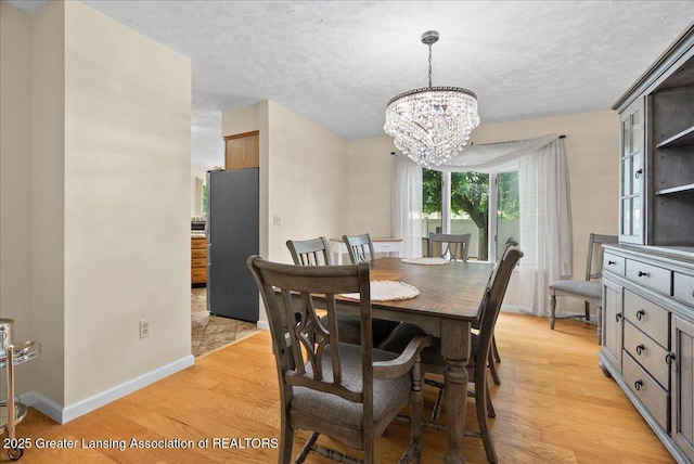 527 Day Rd, Owosso, MI 48867 - dining space with a chandelier, light wood-type flooring, and a textured ceiling