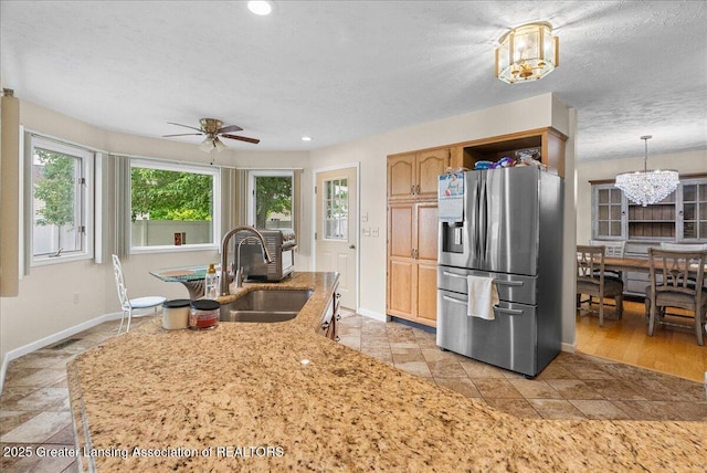 527 Day Rd, Owosso, MI 48867 - kitchen with stainless steel fridge, a ceiling fan, a chandelier, recessed lighting, and light stone countertops