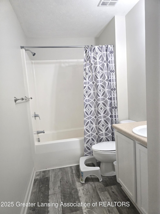 12907 Townsend Dr Unit 612, Grand Ledge, MI 48837 - bathroom with wood finished floors, vanity, shower / bath combo, and a textured ceiling