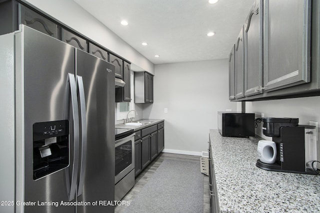 9514 Huntington Rd, Battle Creek, MI 49017 - kitchen with appliances with stainless steel finishes, recessed lighting, light wood-type flooring, light stone countertops, and under cabinet range hood