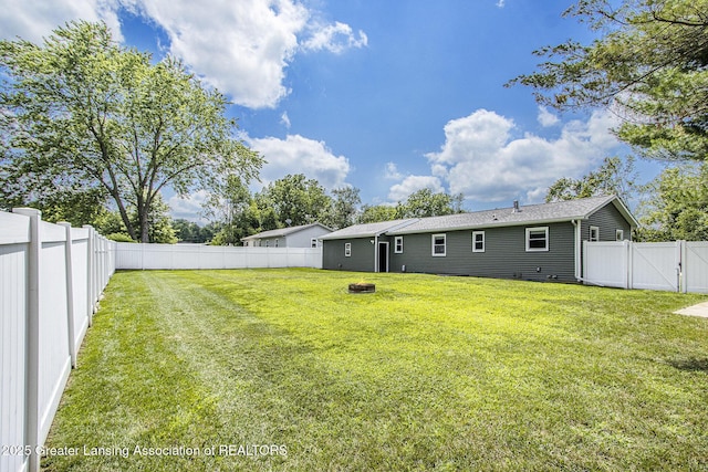 9514 Huntington Rd, Battle Creek, MI 49017 - back of house with an outdoor fire pit, a fenced backyard, and a gate