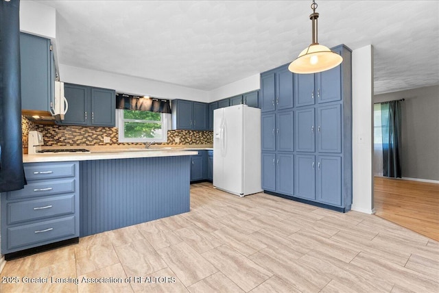 2218 Coolridge Rd, Holt, MI 48842 - kitchen with white appliances, blue cabinetry, a peninsula, and plenty of natural light