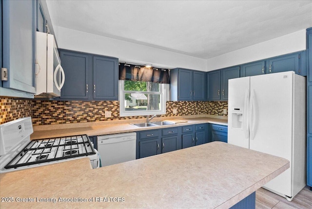 2218 Coolridge Rd, Holt, MI 48842 - kitchen featuring white appliances, blue cabinetry, light countertops, and tasteful backsplash