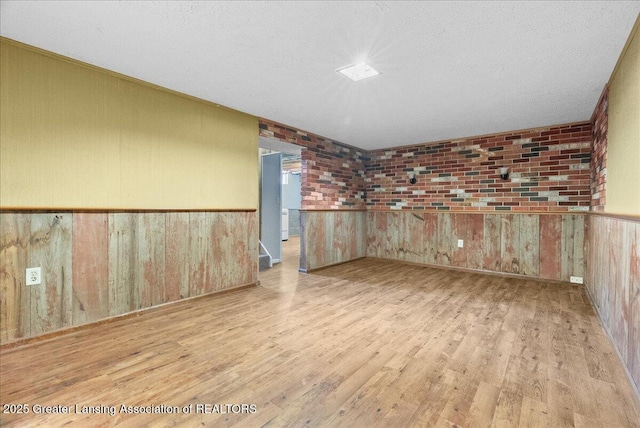 2218 Coolridge Rd, Holt, MI 48842 - spare room with wood finished floors, wooden walls, and wainscoting