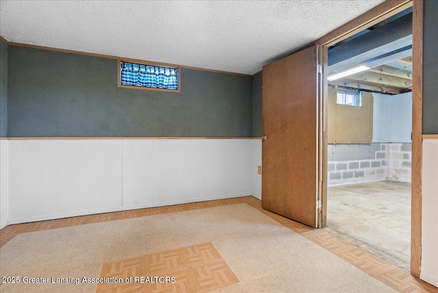 2218 Coolridge Rd, Holt, MI 48842 - below grade area featuring a wainscoted wall and a textured ceiling