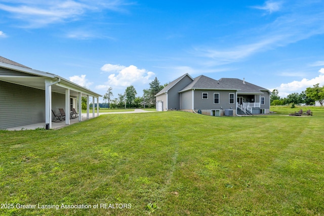14747 Forest Hill Rd, Grand Ledge, MI 48837 - view of grassy yard featuring a garage and a patio area