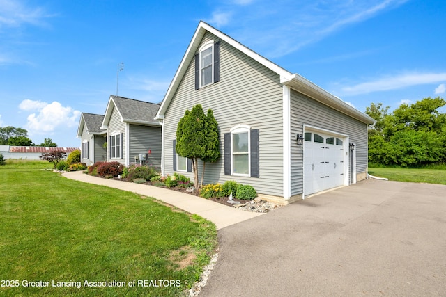 14747 Forest Hill Rd, Grand Ledge, MI 48837 - view of side of home with driveway, a yard, and an attached garage