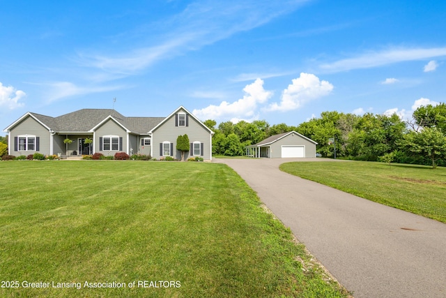 14747 Forest Hill Rd, Grand Ledge, MI 48837 - view of front facade with a detached garage, a front yard, and an outbuilding