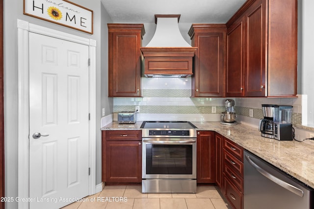 14747 Forest Hill Rd, Grand Ledge, MI 48837 - kitchen with stainless steel appliances, custom range hood, backsplash, light stone countertops, and light tile patterned floors
