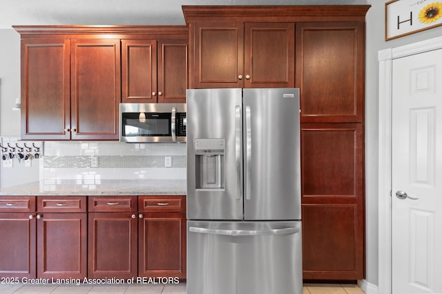 14747 Forest Hill Rd, Grand Ledge, MI 48837 - kitchen featuring appliances with stainless steel finishes, dark brown cabinets, tasteful backsplash, and light stone counters