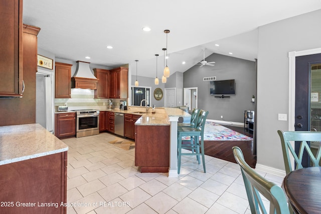 14747 Forest Hill Rd, Grand Ledge, MI 48837 - kitchen featuring stainless steel appliances, a peninsula, a breakfast bar area, lofted ceiling, and a ceiling fan