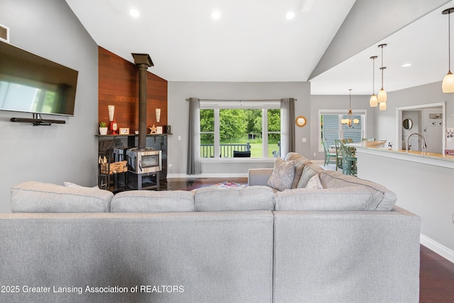 14747 Forest Hill Rd, Grand Ledge, MI 48837 - living room with a wood stove, vaulted ceiling, dark wood finished floors, and recessed lighting