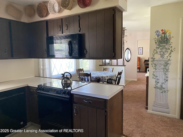 3931 Berry Ridge Dr, Holt, MI 48842 - kitchen featuring black appliances, light carpet, light countertops, a peninsula, and dark brown cabinetry