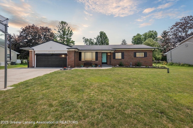 8713 Wintergreen St, Lansing, MI 48917 - single story home featuring an attached garage, concrete driveway, brick siding, and a lawn