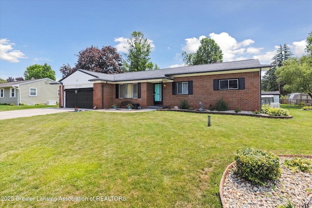 8713 Wintergreen St, Lansing, MI 48917 - ranch-style home with brick siding, driveway, a garage, and a front lawn