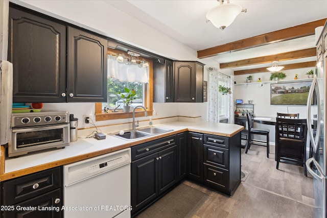 8713 Wintergreen St, Lansing, MI 48917 - kitchen featuring dishwasher, wood finished floors, beamed ceiling, light countertops, and stainless steel refrigerator