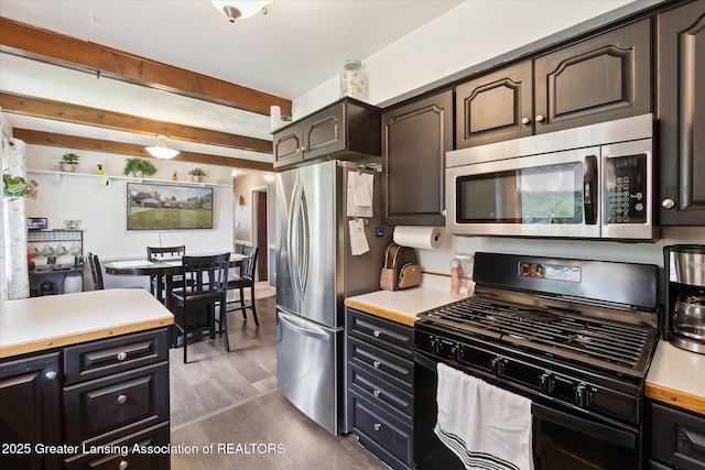 8713 Wintergreen St, Lansing, MI 48917 - kitchen featuring appliances with stainless steel finishes, light countertops, dark wood-type flooring, and beam ceiling