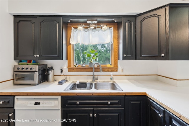 8713 Wintergreen St, Lansing, MI 48917 - kitchen featuring white dishwasher, light countertops, and dark cabinetry