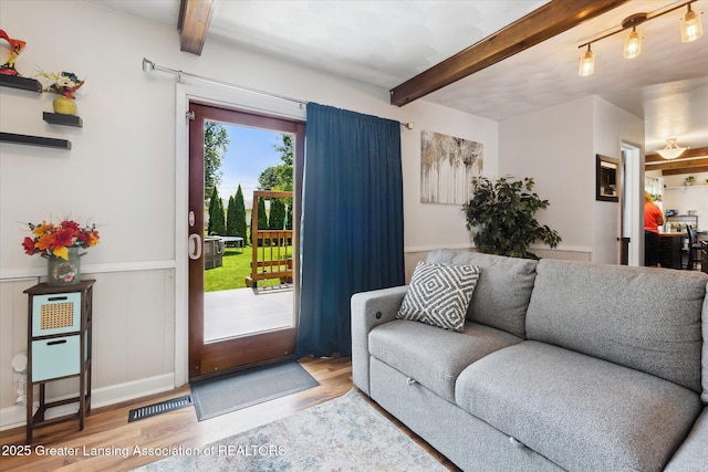 8713 Wintergreen St, Lansing, MI 48917 - living room with beamed ceiling, wood finished floors, and wainscoting