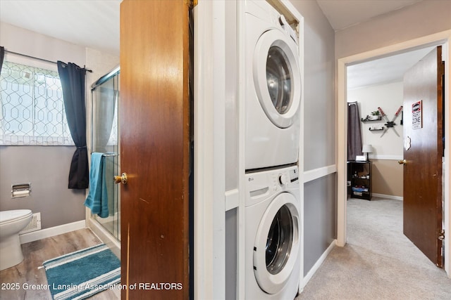 8713 Wintergreen St, Lansing, MI 48917 - washroom featuring estacked washer and dryer and baseboards