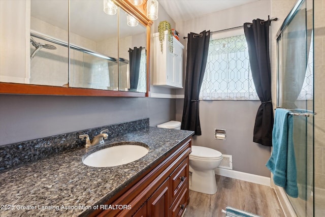 8713 Wintergreen St, Lansing, MI 48917 - full bath with vanity, a stall shower, and wood finished floors
