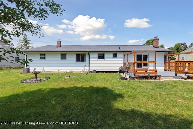 8713 Wintergreen St, Lansing, MI 48917 - back of house with a chimney, a deck, and a yard