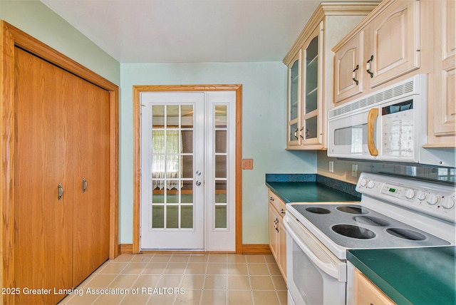 6875 W Howe Rd, Dewitt, MI 48820 - kitchen featuring white appliances, dark countertops, glass insert cabinets, and light tile patterned floors