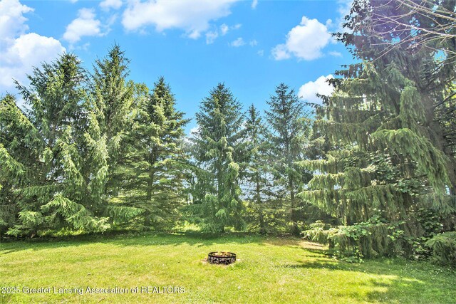6875 W Howe Rd, Dewitt, MI 48820 - view of green lawn featuring an outdoor fire pit