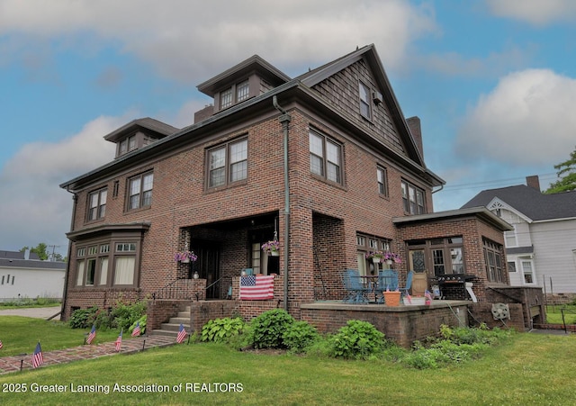 502 S Main St, Eaton Rapids, MI 48827 - back of house featuring brick siding and a yard