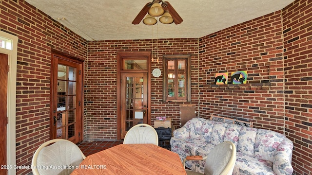 502 S Main St, Eaton Rapids, MI 48827 - dining area featuring brick wall, a textured ceiling, and a ceiling fan
