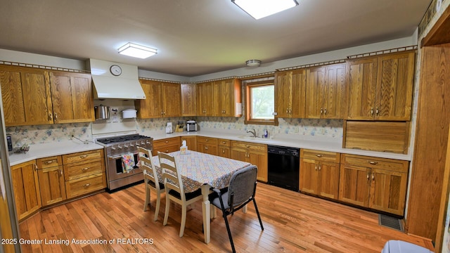 502 S Main St, Eaton Rapids, MI 48827 - kitchen featuring high end stove, black dishwasher, brown cabinets, and tasteful backsplash