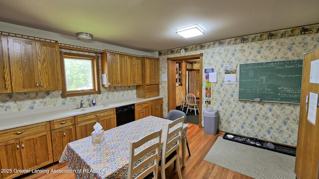 502 S Main St, Eaton Rapids, MI 48827 - kitchen with dishwasher, wallpapered walls, brown cabinetry, light wood-type flooring, and light countertops