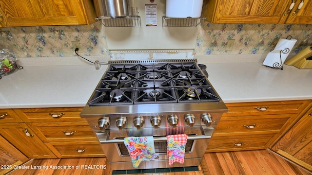 502 S Main St, Eaton Rapids, MI 48827 - kitchen featuring double oven range, light countertops, brown cabinets, and wood finished floors