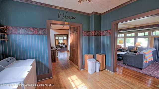 502 S Main St, Eaton Rapids, MI 48827 - laundry room with light wood finished floors, washing machine and clothes dryer, ornamental molding, and a textured ceiling