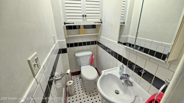 502 S Main St, Eaton Rapids, MI 48827 - half bathroom with tile walls and a wainscoted wall
