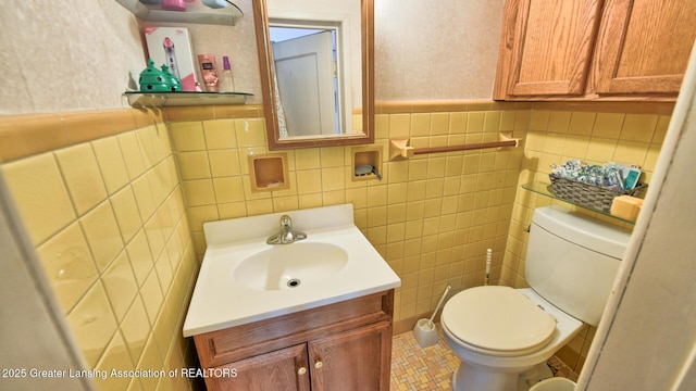 502 S Main St, Eaton Rapids, MI 48827 - half bath featuring vanity, tile walls, and a wainscoted wall