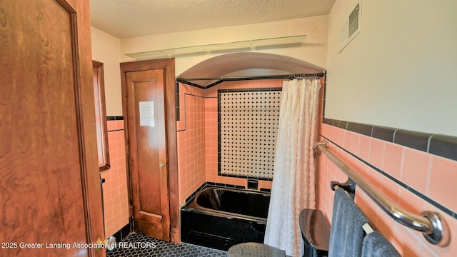 502 S Main St, Eaton Rapids, MI 48827 - bathroom with a bath, tile walls, curtained shower, tile patterned flooring, and a wainscoted wall