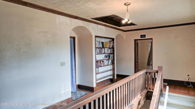 502 S Main St, Eaton Rapids, MI 48827 - hallway featuring arched walkways, an upstairs landing, crown molding, a textured ceiling, and wood finished floors