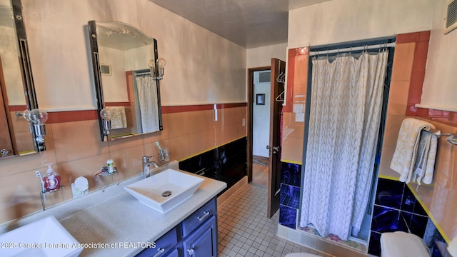 502 S Main St, Eaton Rapids, MI 48827 - full bath featuring vanity, tile walls, a shower with curtain, and tile patterned floors