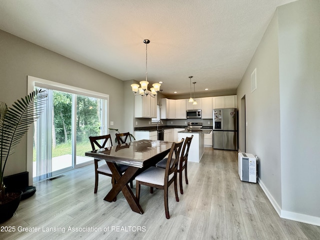 4314 Ringneck Ln, Holt, MI 48842 - dining area featuring a chandelier, light wood-style flooring, and recessed lighting