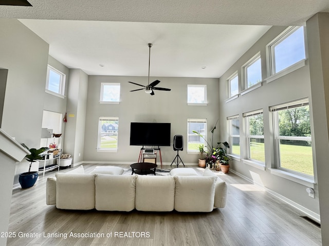 4314 Ringneck Ln, Holt, MI 48842 - living room featuring wood finished floors, a towering ceiling, and ceiling fan