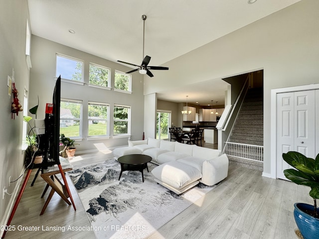 4314 Ringneck Ln, Holt, MI 48842 - living area featuring stairs, wood finished floors, ceiling fan, and a high ceiling