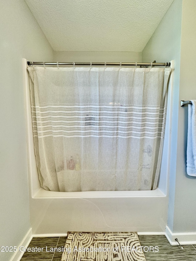 4314 Ringneck Ln, Holt, MI 48842 - bathroom featuring shower / tub combo and a textured ceiling