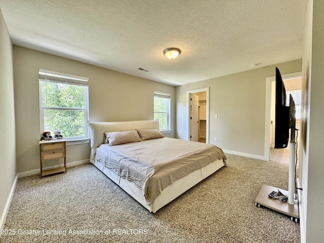 4314 Ringneck Ln, Holt, MI 48842 - carpeted bedroom featuring a textured ceiling and a walk in closet