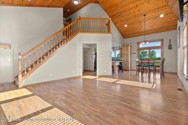 5159 E Pratt Rd, Saint Johns, MI 48879 - unfurnished living room with high vaulted ceiling, wood ceiling, stairway, wood finished floors, and a chandelier