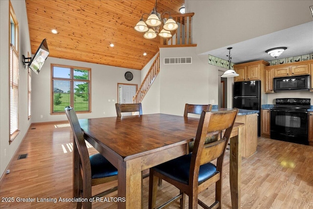 5159 E Pratt Rd, Saint Johns, MI 48879 - dining area featuring stairway, a chandelier, light wood-type flooring, and a high ceiling