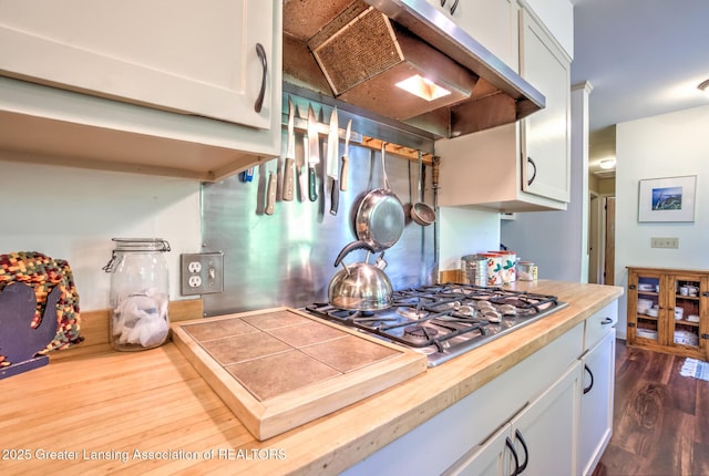4451 Greenwood Dr, Okemos, MI 48864 - kitchen with stainless steel gas cooktop, premium range hood, dark wood-style floors, white cabinetry, and wood counters