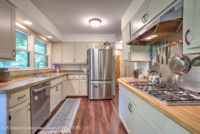 4451 Greenwood Dr, Okemos, MI 48864 - kitchen featuring appliances with stainless steel finishes, under cabinet range hood, dark wood-style flooring, white cabinets, and recessed lighting