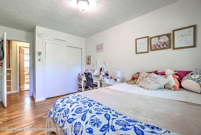 4451 Greenwood Dr, Okemos, MI 48864 - bedroom with wood finished floors, a textured ceiling, and a closet